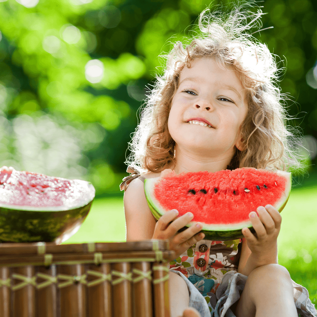 Barn smiler med melon – sommeraktiviteter for barn i Oslo i det grønne