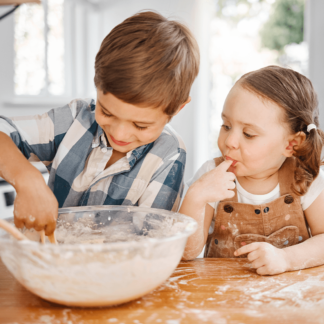 Siblings baking together and enjoying a calm holiday moment.